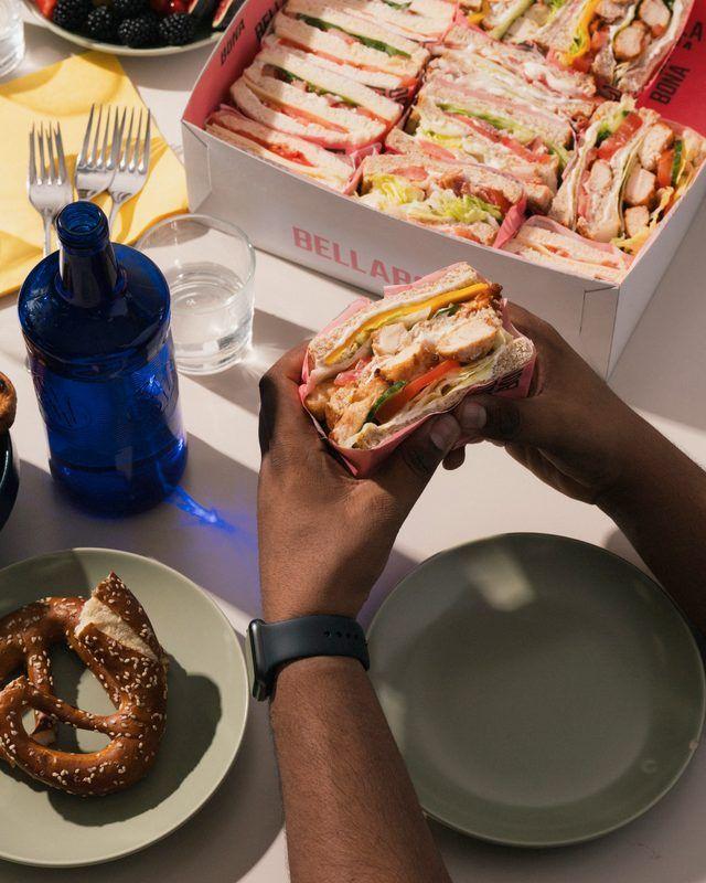 Hands holding a fresh Bella&Bona sandwich