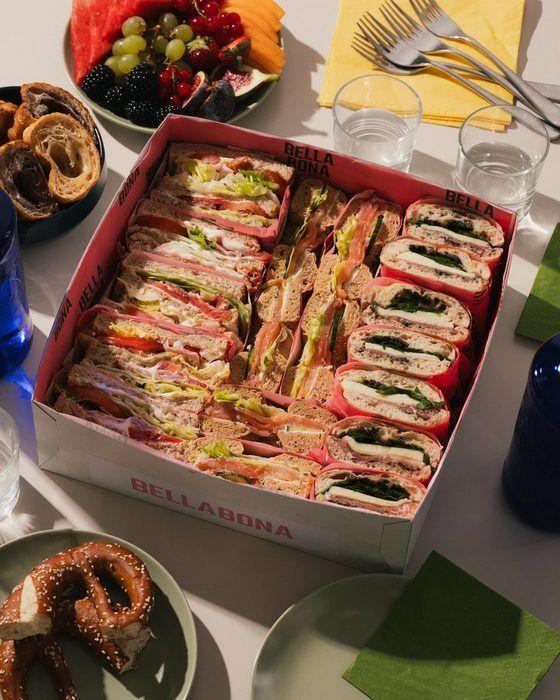 A catering box of fresh sandwiches with sides
