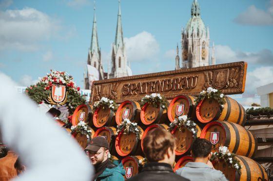 Decorated beer barrels at Oktoberfest with Munich's Frauenkirche towers in the background