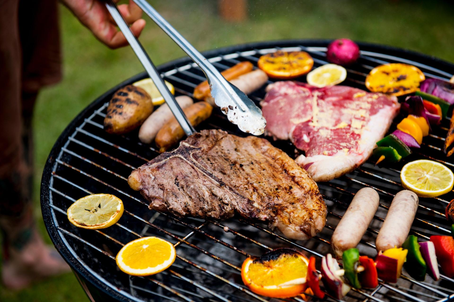 Premium BBQ with steak, sausages and grilled fruit on the grill