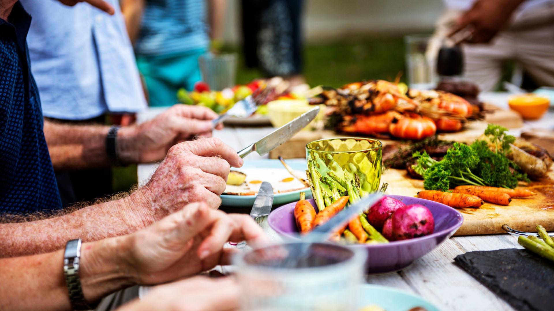 Gäste bedienen sich an einem bayerischen BBQ-Buffet bei einem Outdoor-Event