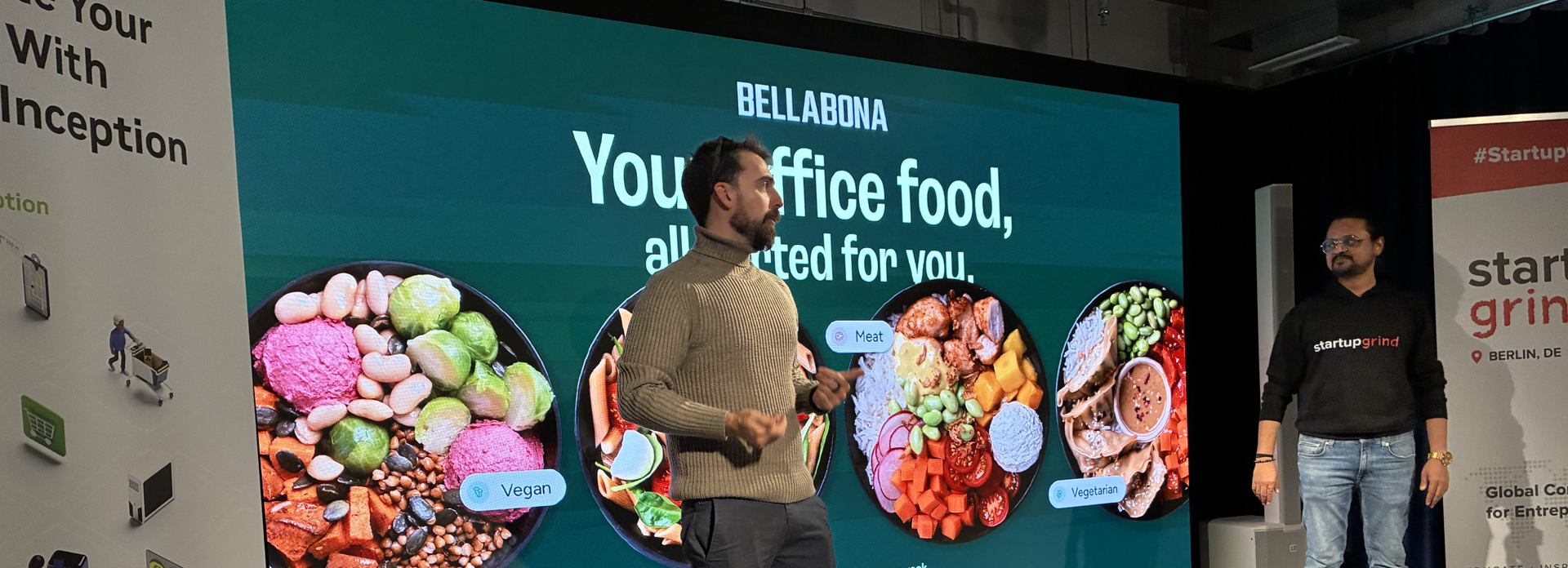 Matteo Cricco presenting Bella&Bona on stage in front of a screen with vegan, vegetarian and meat bowls