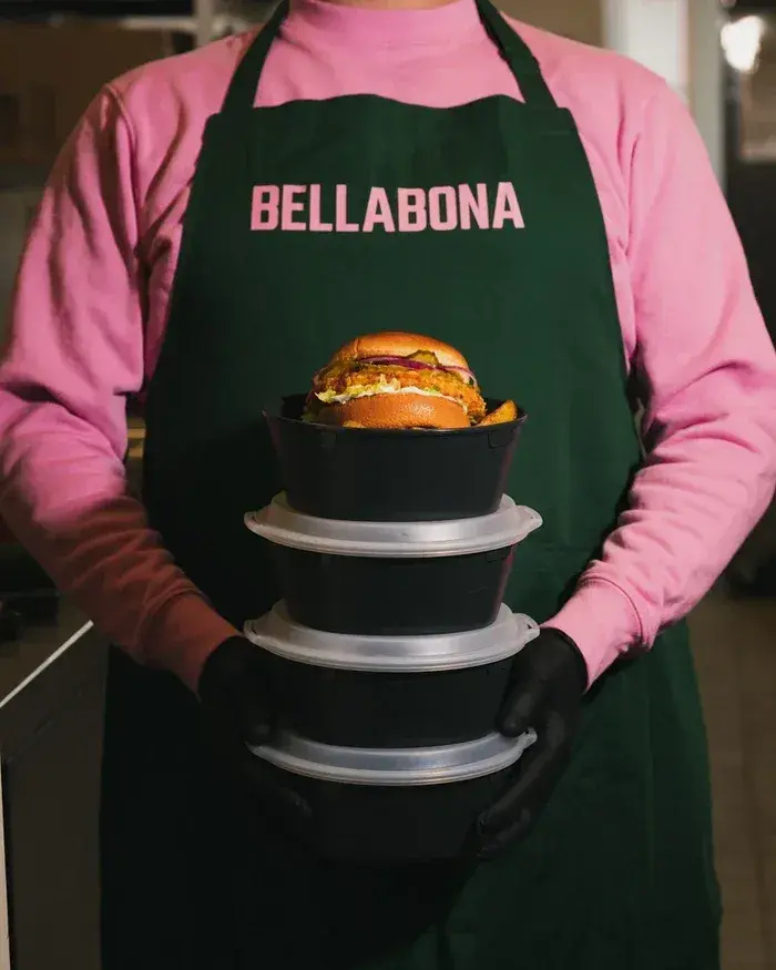 Bella&Bona team member holding stacked meal bowls