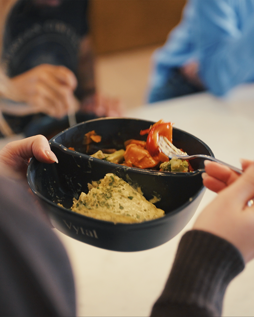 Hands holding a fresh Bella&Bona meal bowl