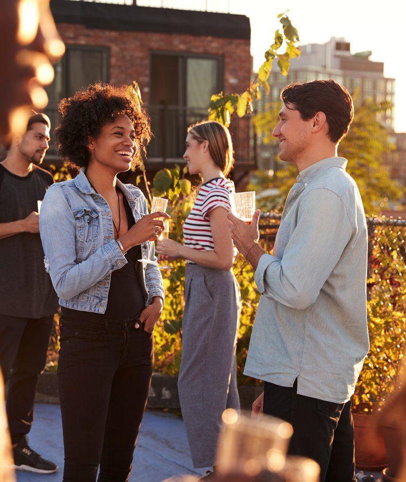 Colleagues celebrating with drinks at a rooftop summer party