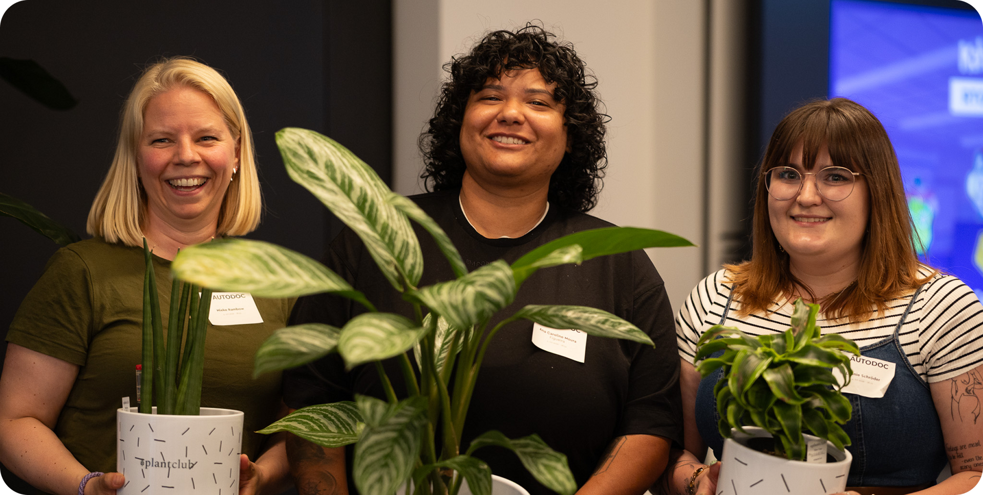 Colleagues holding potted plants at a team event