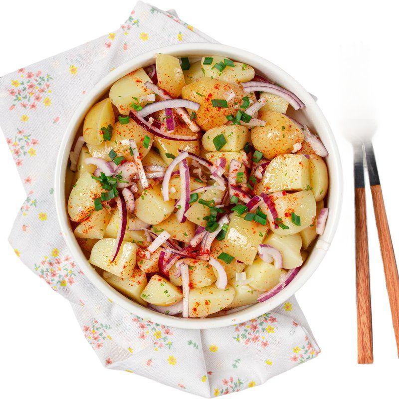 Potato salad topped with red onion and chives
