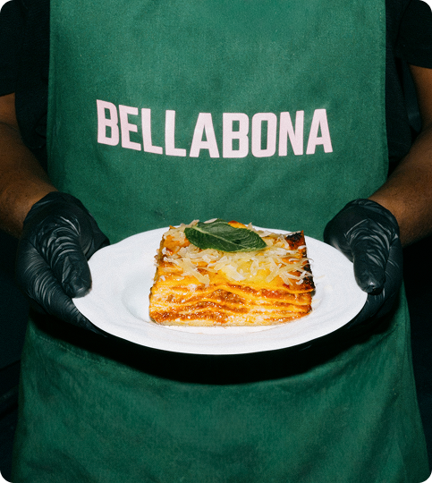 Bella&Bona chef holding a plate of freshly baked lasagna