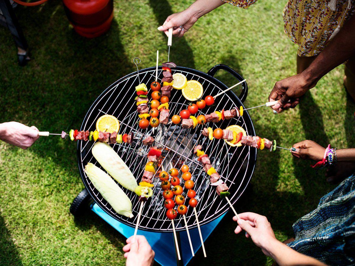 Colleagues grilling skewers and vegetables at a summer BBQ