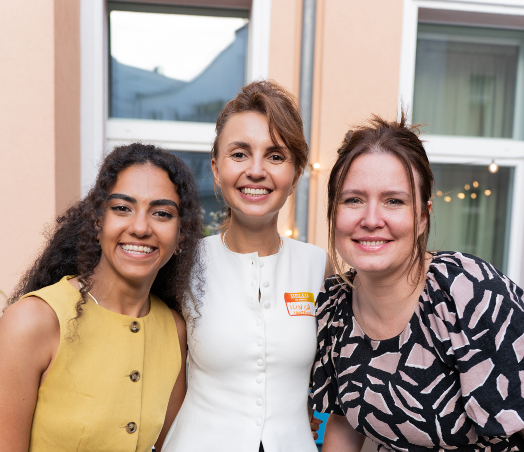 Three guests smiling together on a terrace