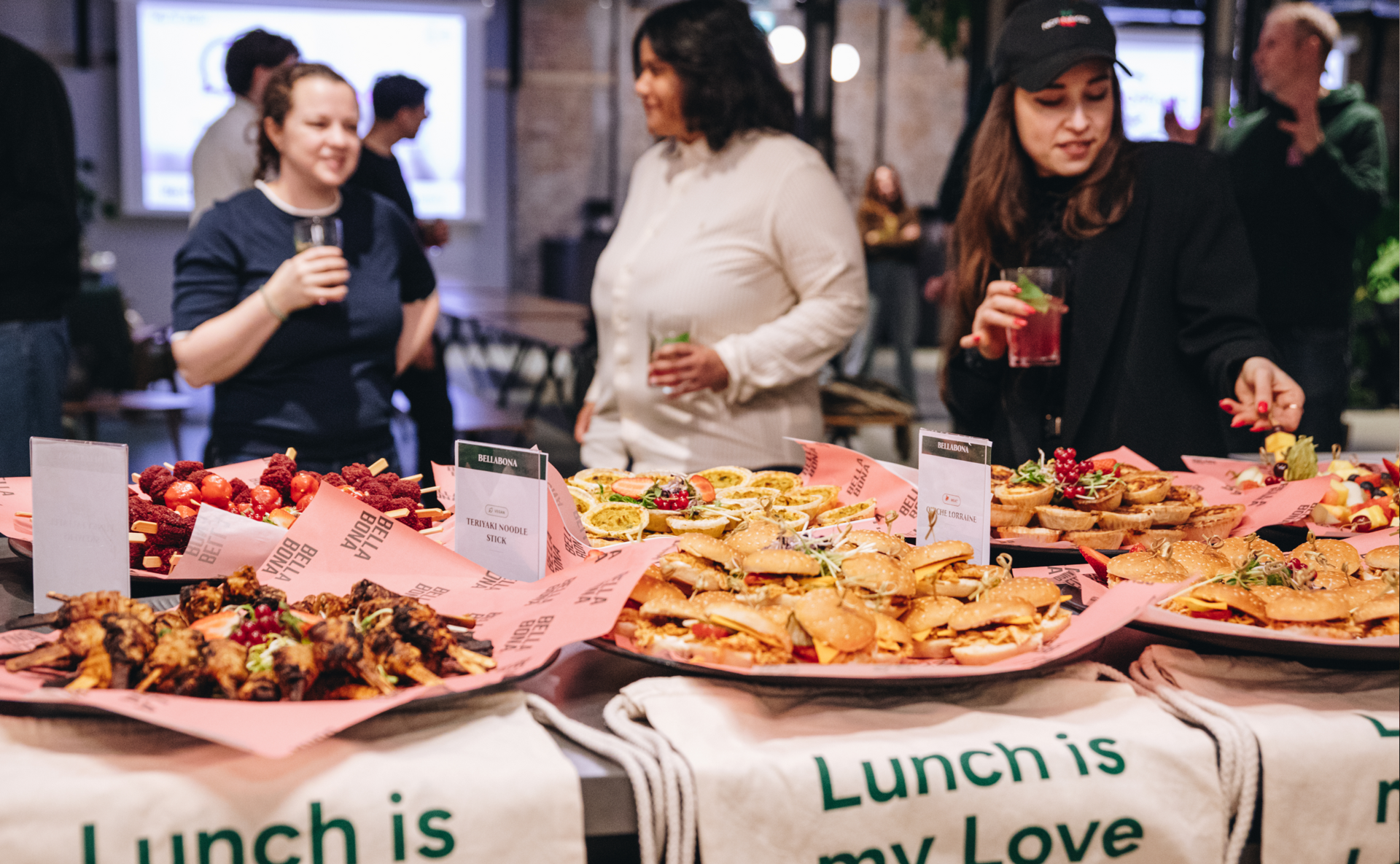 Gäste mit Getränken an einem Bella&Bona Catering-Tisch während eines Büro-Events
