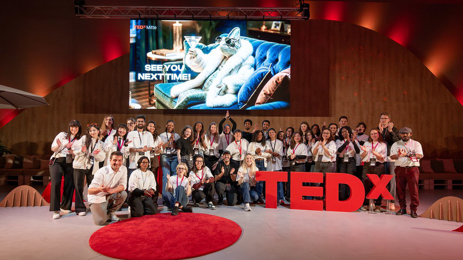 The TEDxMitte 2026 team and volunteers on stage next to the TEDx letters