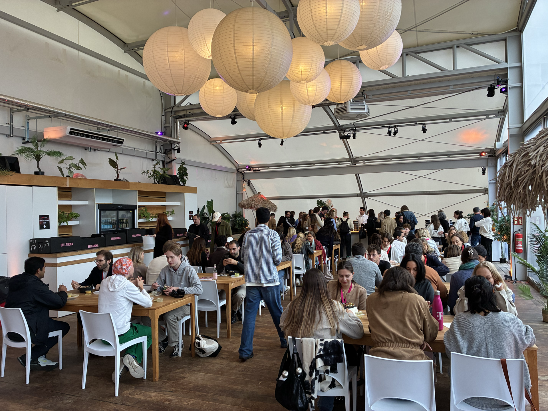 Guests having lunch under paper lanterns in the TEDxMitte lunch hall