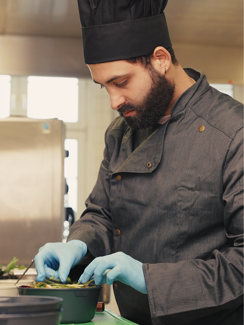 Chef plating a dish in a Bella&Bona kitchen