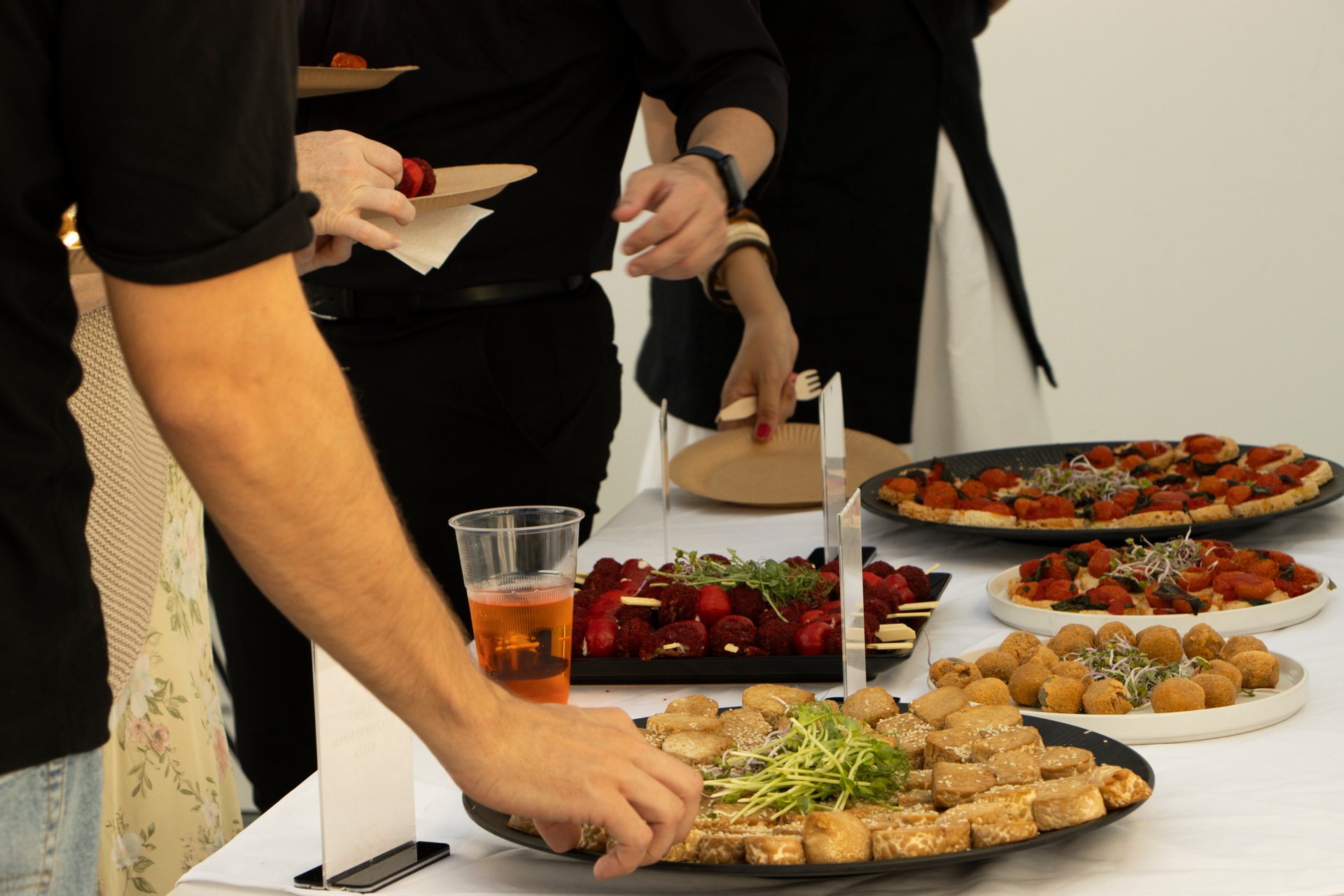 Catering-Buffet mit Gebäck, Salaten und frischen Gerichten auf einem Tisch am hellen Bürofenster