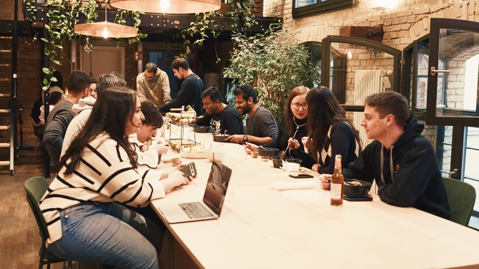 Atolls employees sharing lunch at a long table in their Berlin office