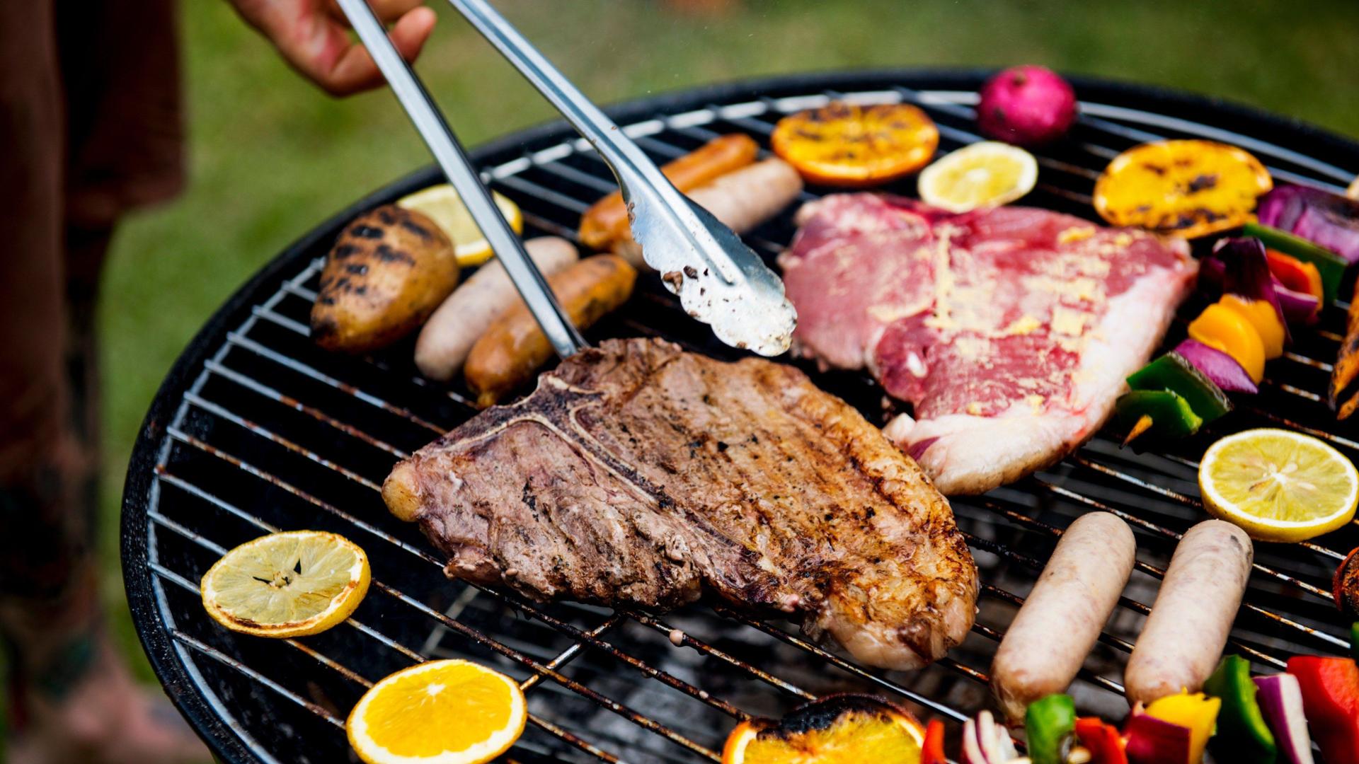 Live grill setup with steak, sausages and grilled fruit for an Oktoberfest-themed catering event