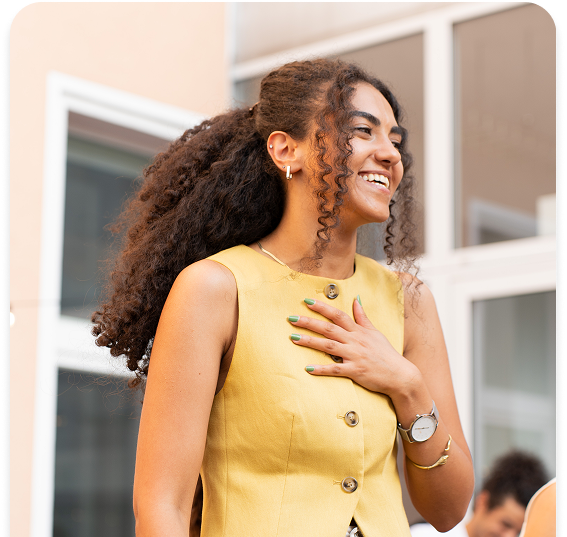 A guest laughing with a hand on their chest